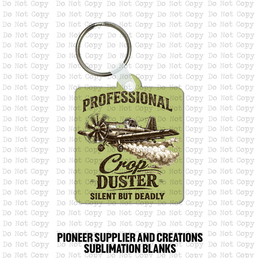 Custom-shaped contoured MDF wood sublimation keychain blank kit featuring a vintage cartoon style crop duster airplane and text that says Professional Crop Duster Silent But Deadly, shown with keyring hardware.
