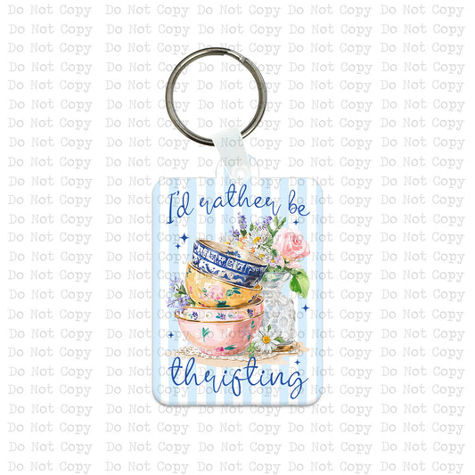 Custom-shaped contoured vertical MDF wood sublimation keychain blank kit featuring a watercolor design of stacked antique teacups and the text I'd rather be thrifting, shown with keyring hardware.