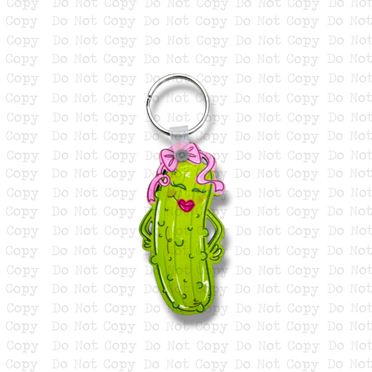 Custom-shaped contoured MDF wood sublimation keychain blank kit featuring a sassy cartoon pickle wearing a pink bow and pink lipstick, shown with keyring hardware.